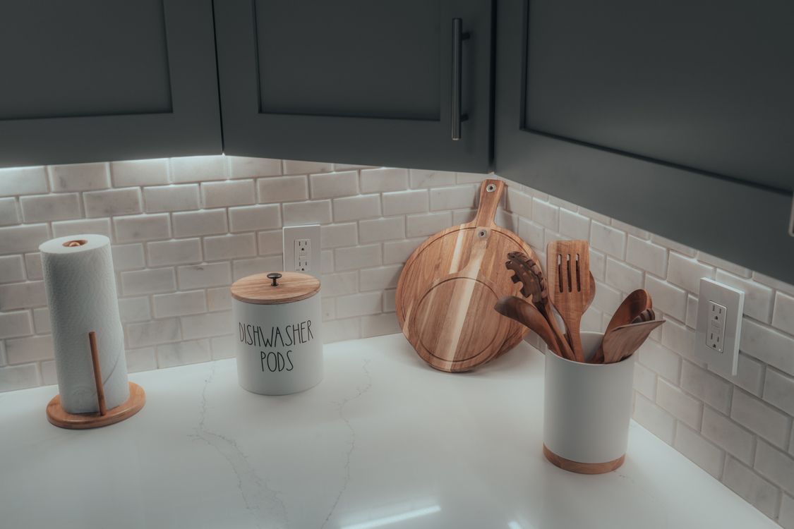 Bright kitchen counter neatly arranged with wooden utensils and containers.